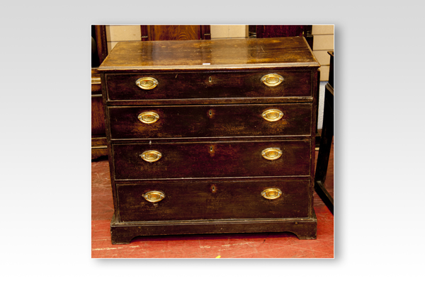 An early 19th Century oak chest of four long graduated drawers with brass oval plate handles on