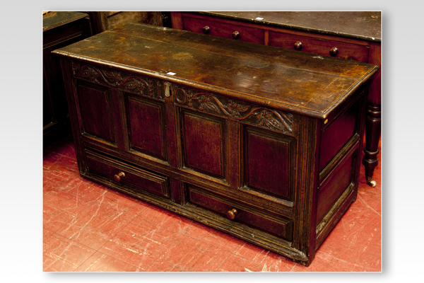 An 18th Century oak dower chest having a narrow top floral panel over four fielded panels and with