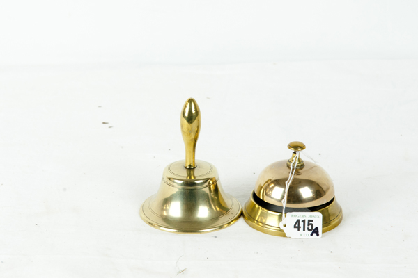 A circular brass foot bell and a small brass hand bell