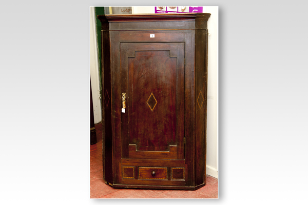 A 19th Century oak single door hanging corner cupboard, the door and angled side panels having