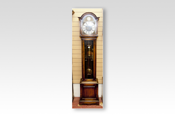 An early 20th Century polished encased grandmother clock having a domed hood with silvered dial, a