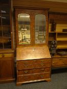 An early eighteenth century figured walnut bureau bookcase, the upper section having a pair of