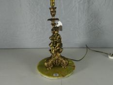 An ormolu electric table-lamp in the form of tree-trunk with a seated cherub in robes above a