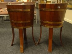 A pair of brass planters in the form of barrels on stands