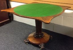 A Victorian rosewood foldover card table having a circular base on scrolled feet and with tapered