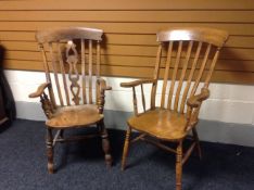 Two antique Welsh farmhouse elm elbow chairs, one having a shaped central splat