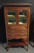 An elegant Edwardian bowed mahogany music-cabinet having a shaped base shelf, three fall-front