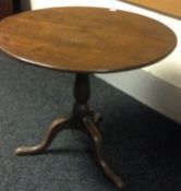 A nineteenth century oak tilt-top tripod table 31ins diameter