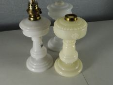 Three circular based milk-glass oil-lamp bases (one with chimney)