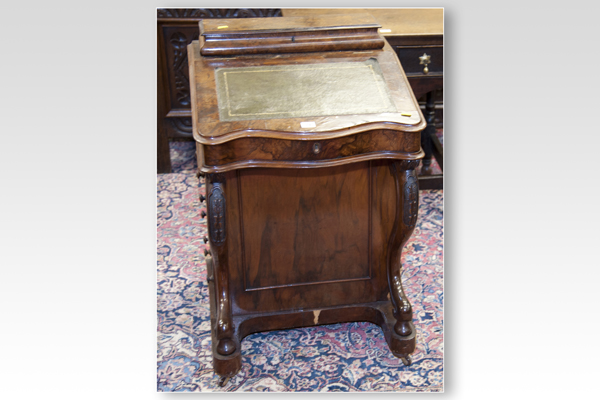 A Victorian walnut Davenport desk with scrolled and curved `piano` supports