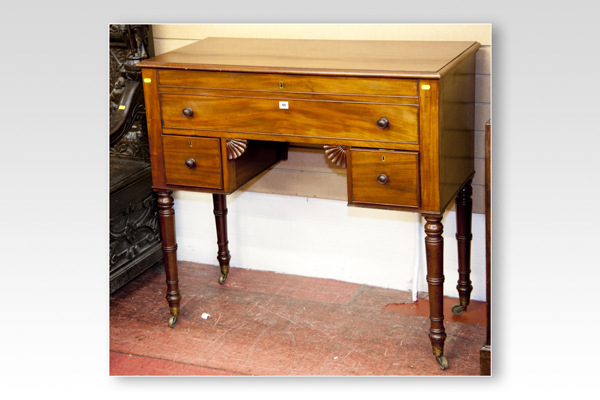 A Victorian mahogany kneehole writing desk, the rising top having a hinged lid with a long false