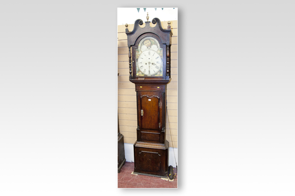An early 19th Century oak and crossbanded long case clock having an arched hood with painted dial,