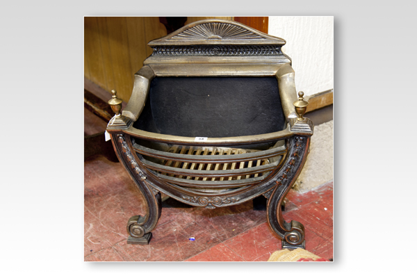 An Adams style cast iron dog grate having a fan decorated top bar and curved and scrolled front