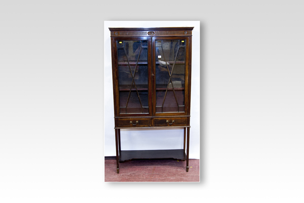 An Edwardian mahogany two door china cabinet with two drawers and an open base shelf with square