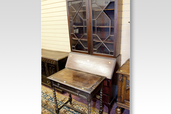 An Edwardian mahogany bookcase bureau with two drawers, a slope front and three drawers below; and a