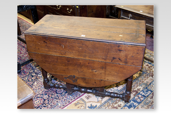 A 19th Century oval topped oak drop-leaf dining table with turned and block supports