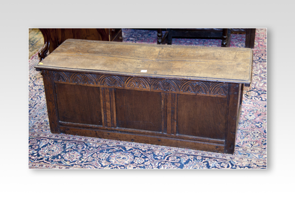 A small antique oak blanket chest with carved narrow lunette top panel and three inset panels below