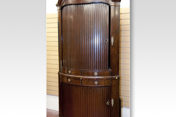 A substantial bow front mahogany standing corner cupboard, the upper section having a full length