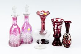 A pair of pink overlaid glass bell shaped decanters; a red overlaid glass trumpet vase; two other