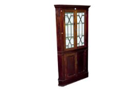 A one piece standing mahogany corner cupboard, the two upper glazed doors having astragal panes with