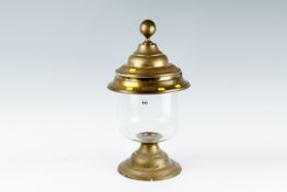 A substantial brass based glass candle lamp having a brass domed and stepped cover