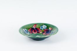 A Moorcroft green ground circular shallow pedestal dish `Frilled and Slipper Orchids`, 9.75 ins (