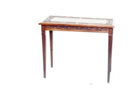 An early 20th Century oblong topped mahogany writing table having a carved leaf and dolphin border