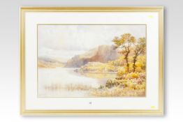 ARTHUR SUKER watercolour; lake scene with crags and trees, signed, 18 x 27 ins (36 x 69 cms)