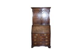 A late 18th Century oak one piece bookcase bureau, the upper section having two doors with domed