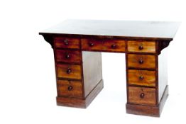 A late Victorian mahogany kneehole desk having a centre drawer and four graduated drawers either