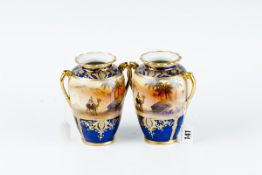 A pair of Noritake twin handled desert scene vases, blue and gilt with central wide panel of camel