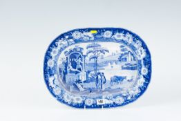 An oval blue and white meat platter - two classical figures on a ruin with two peasants and two