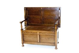 A polished box seat monk`s bench with narrow carved decoration