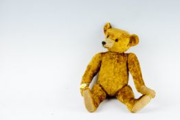 An early, believed Steiff, dark yellow plush teddy bear having `triangular` head with bead eyes