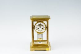 A brass encased four glass mantel clock, eight day French movement striking on a bell, with
