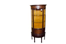 An Edwardian mahogany and garland inlaid drum shaped standing corner display cabinet having a