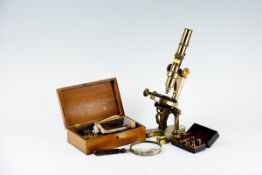 An uncased brass microscope marked `Nachet Opticien, Paris`, together with a mahogany case of sundry