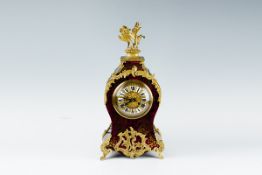 A large ebonised balloon style clock, the front of ormolu and red tortoiseshell, rococo style