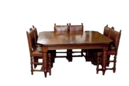 A substantial Edwardian oak extending dining table on two corner supports and having two leaves,
