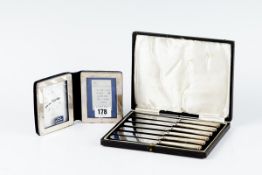 A cased set of six silver handled tea knives; and a modern sterling silver framed travelling clock