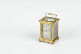 A brass encased carriage clock having engine turned brasswork with etched glass side panels and an