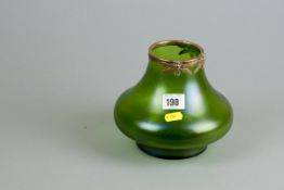 A green iridescent onion shaped vase on a short pedestal and with a brass collar with three