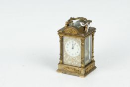 A brass encased carriage clock with bevelled panels and a domed top with bevelled window and