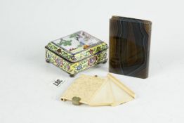 A near square lidded enamel box with figure decoration to the lid, on corner supports (