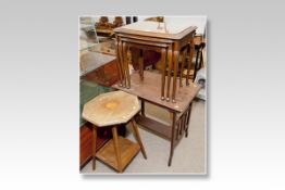 A nest of three walnut coffee tables with glass tops; an Edwardian mahogany two tier octagonal table