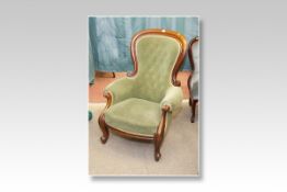 A Victorian mahogany button backed gentleman`s armchair with cabriole supports