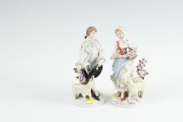 A pair of early 20th Century Continental figurines - young bonneted girl with basket of flowers