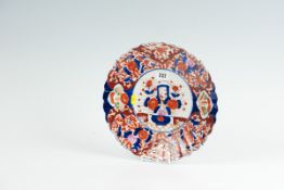 An early 20th Century circular Imari charger with a wavy border and a central basket and posy of