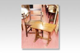 An elm seated 19th Century elbow chair; and a polished reproduction rustic trestle style coffee