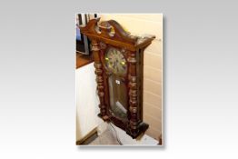 A mahogany encased Vienna style pendulum wall clock having a circular silvered dial and brass